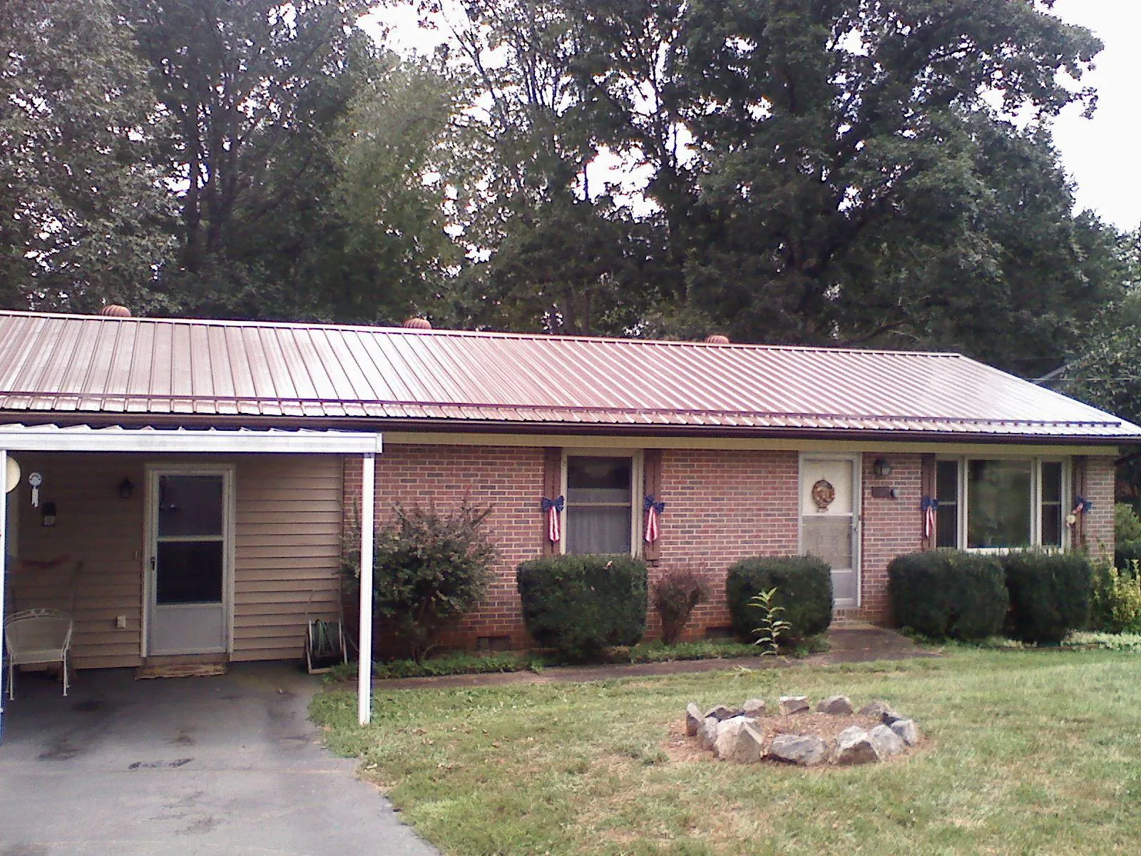 Bronze metal roof and carport on a brick ranch home — Roof Repair work by our crew in Englewood